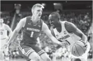  ?? Rey Del Rio, Getty Images ?? Joshua Langford of Michigan State drives while being defended by Wisconsin’s Brevin Pritzl in East Lansing, Mich., on Friday night.