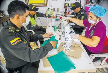  ?? JESúS RICO ?? Enith Gazabón y los policías del Grupo de Prevención y Educación Ciudadana, cosen tapabocas verdes.