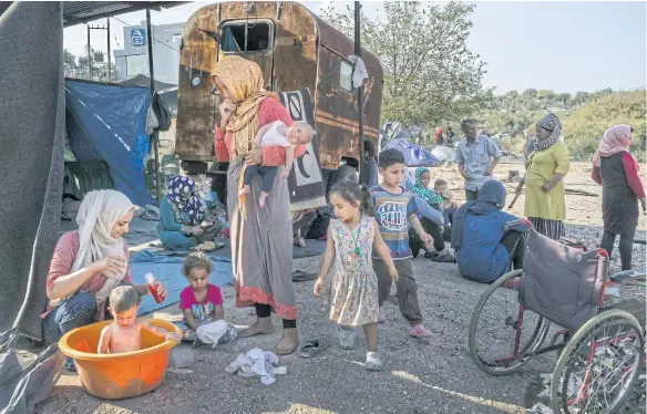  ?? PHOTOS: MAURICIO LIMA/THE NEW YORK TIMES ?? Women with their children in a field near the beach after they were displaced from the destroyed Moria migrant camp on Lesbos in Greece on Sept 12.