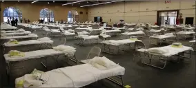  ?? AP PHOTO BY BEN MARGOT ?? In this April 1 file photo, cots are set up at a possible COVID-19 treatment site in San Mateo, Calif. As tens of thousands of retired healthcare workers and medical and nursing students sign up for the newly establishe­d California Health Corps, almost nothing is known about how it will operate, how much it will cost and whether taxpayers will be liable for any malpractic­e.