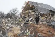  ?? Efrem Lukatsky Associated Press ?? A LOCAL takes a photo of a missile crater and the debris of a house ruined in a Russian attack in Kyiv.