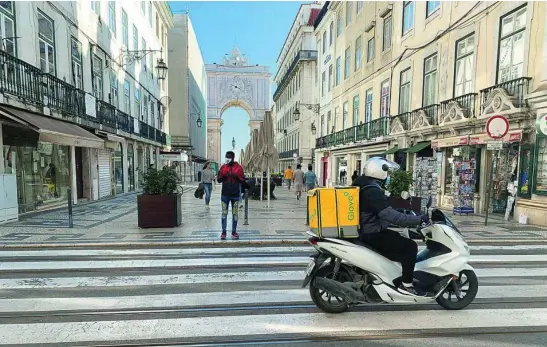  ?? EFE ?? Una popular calle de Lisboa con los comercios abiertos a medio gas