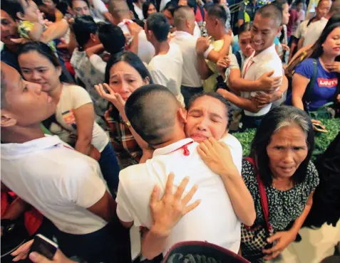  ?? ALDO NELBERT BANAYNAL ?? New PNP recruits bid goodbye to their loved ones during their oathtaking last Monday. They are set to go into rigid training.