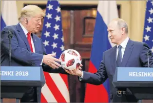  ?? AP PHOTO ?? Russian President Vladimir Putin gives a soccer ball to U.S. President Donald Trump, left, during a press conference after their meeting at the Presidenti­al Palace in Helsinki, Finland, on Monday,