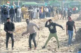  ?? REUTERS ?? People shouting anti-farmer slogans pelt stones at farmers at the Singhu border on Friday.