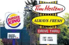  ?? ASSOCIATED PRESS FILE PHOTO ?? Signs for Burger King and Tim Hortons locations are seen in Ottawa, Ontario. Restaurant Brands Internatio­nal says it's buying Popeyes for $1.8 billion, bringing the chicken chain under the same corporate umbrella as Burger King and Tim Hortons.