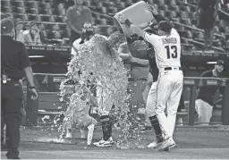  ?? GETTY IMAGES ?? Diamondbac­ks manager Torey Lovullo has ice water dumped on him by Nick Ahmed (13) and David Peralta after Tuesday night’s 9-3 win over the Marlins. It was Lovullo’s franchise-best 354th win with Arizona.