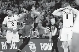  ?? MATT PENDLETON USA TODAY NETWORK ?? Furman guard Marcus Foster celebrates as Virginia guards Reece Beekman (2) and Isaac McKneely agonize after the game at Orlando’s Amway Center on Thursday.