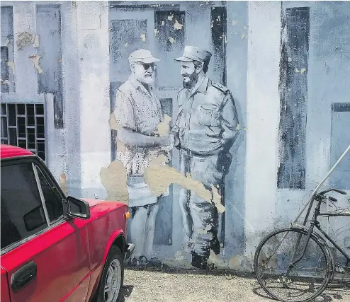  ?? RAMON ESPINOSA / THE ASSOCIATED PRESS ?? Ernest Hemingway and Fidel Castro meet in a mural on a downtown parking lot in Havana.