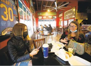  ?? Al Seib Los Angeles Times ?? KAYLA HARRAPENCE, left, enjoys lunch with her mother, Brandi Harrapence, at Firestone Grill last week in downtown San Luis Obispo as the county moved into the red tier, allowing for limited indoor dining.