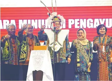  ??  ?? Abang Johari,dressed in Orang Ulu traditiona­l gear, leads the Gawai toast based on the Kenyah’s traditiona­l way of toasting. Also in the photo are (from left) Masing, Uggah, Datin Amar Datuk Juma’ani Tun Tuanku Bujang and Datin Amar Doreen Mayang.