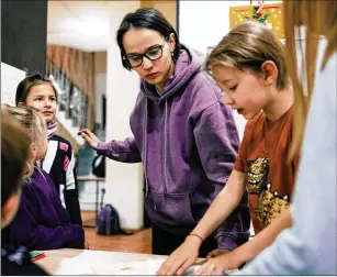  ?? PHOTOS BY TAKO ROBAKIDZE FOR THE WASHINGTON POST ?? Geography teacher Polina Primak helps students with homework last month at the Liberated School in Yerevan, Armenia. “We try to make learning as close as possible to how we would have liked to have been taught when we were at school,” she said.