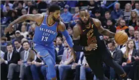  ?? SUE OGROCKI - THE ASSOCIATED PRESS ?? Cavaliers forward LeBron James drives past Thunder forward Paul George during the first half in Oklahoma City on Feb. 13.