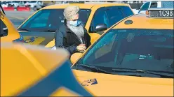  ?? AFP ?? A yellow cab taxi driver cleans his car as he waits in line at a taxi hold at Laguardia Airport in New York City.