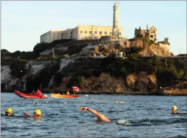  ?? ARIC CRABB — BAY AREA NEWS GROUP ?? Swimmers make their way from Alcatraz Island to the South End Rowing Club in San Francisco during an event last month on San Francisco Bay.