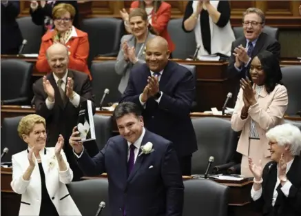  ?? NATHAN DENETTE, THE CANADIAN PRESS ?? Ontario Finance Minister Charles Sousa, centre delivers the 2017 Ontario budget next to Premier Kathleen Wynne, left, at Queen’s Park in Toronto on Thursday.