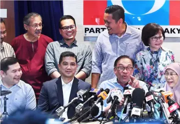  ??  ?? Anwar (seated second right) gestures at the press conference at PKR headquarte­rs. Also seen seated from right are Wan Azizah, Azmin and Rafizi. — Bernama photo