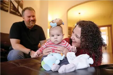  ?? Chris Sweda/Chicago Tribune/TNS ?? ■ Angie Wall, 43, and husband Mike Wall, 43, play with their son Nicholas, 5 months, at their home in Chicago’s Wrigleyvil­le neighborho­od.