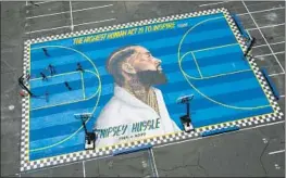  ?? Brian van der Brug Los Angeles Times ?? A MURAL of rapper Nipsey Hussle adorns the court at a South L.A. school.