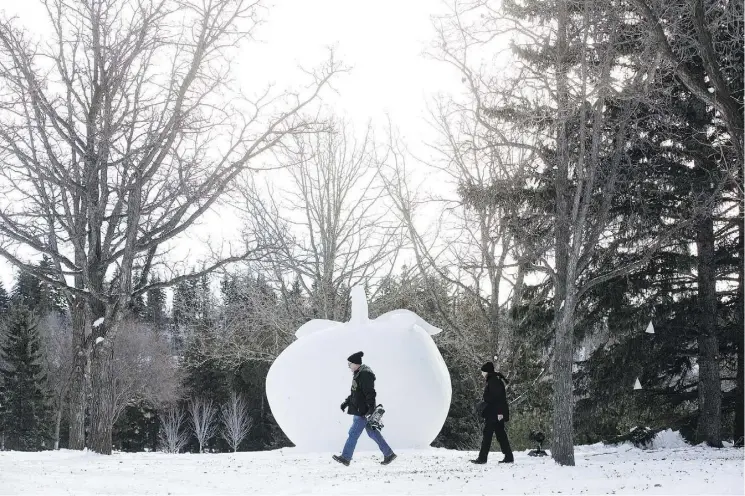  ?? DAVID BLOOM/FILES ?? Visitors to last year’s Silver Skate Festival in Hawrelak Park walk past a snow sculpture.