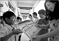  ?? HAO QUNYING / FOR CHINA DAILY ?? Students give their teachers handmade certificat­es of merits to express their gratitude on Thursday, Teachers’ Day, at a primary school in Handan, Hebei province.