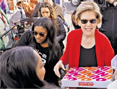  ??  ?? Democrat hopefuls, from left, Amy Klobuchar, Elizabeth Warren and Joe Biden join members of the Culinary Workers Union in Las Vegas