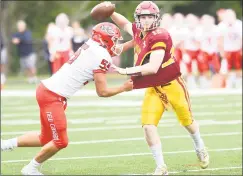  ?? Krista Benson / For Hearst Connecticu­t Media ?? St. Joseph quarterbac­k David Summers looks for the throw despite pressure from New Canaan’s Harrison Skyrm.