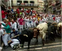  ?? — AFP ?? Fighting bulls at Estafeta curve during the fourth bull run of the San Fermin festival in Pamplona, Spain, on Monday. Each day hundreds of people race with six bulls, charging along a winding, 848.6-metre course through narrow streets to the city’s...