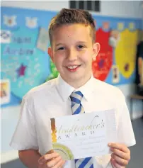  ??  ?? Fantastic feat Calum receives the headteache­r’s award for 100 per cent attendance