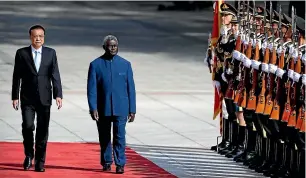  ?? AP ?? Chinese Premier Li Keqiang, left, and Solomon Islands Prime Minister Manasseh Sogavare review an honour guard during a welcome ceremony at the Great Hall of the People in Beijing in October 2019. Sogavare’s government signed a new security agreement with China earlier this month.