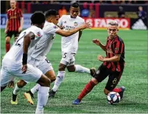  ?? CURTIS COMPTON / CCOMPTON@AJC.COM ?? United midfielder Ezequiel Barco works the ball away from FC Cincinnati defenders Alvas Powell (from left), Victor Ulloa and Allan Cruz during their match on Sunday.