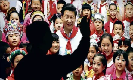  ?? Andy Wong/Associated Press ?? Foto em Pequim mostra o presidente chinês, Xi Jinping, com crianças e ressalta seus feitos nos últimos cinco anos