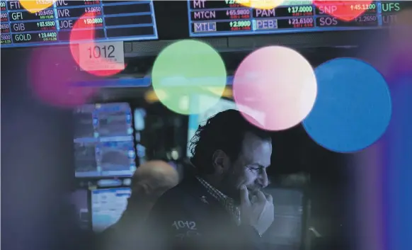  ?? AP ?? A trader at the New York Stock Exchange on Friday. Stocks closed sharply lower on news of the coronaviru­s variant