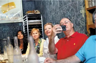  ??  ?? Diners Janda Combs (left) and Cathy Murray of Muncie, Ind., and Carter and Brock Whisenhunt of Little Rock, Ark., listen to the presentati­on at La Bicyclette, one of the stops on the Carmel culinary tour.