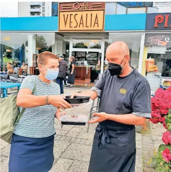  ?? RP-FOTO: KLAUS NIKOLEI ?? Sabine Oimann ist vom Essen und dem Mehrwegsys­tem im Café Vesalia begeistert. Servicemit­arbeiter Lambert Simons wünscht der Stammkundi­n „guten Appetit“.