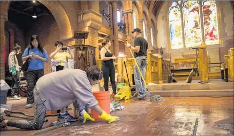  ?? Photograph­s by Jay L. Clendenin Los Angeles Times ?? VOLUNTEERS CLEAN UP damage caused by a fire set by vandals at the 129-year-old Church of the Angels in Pasadena on Jan. 13.