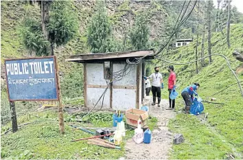  ??  ?? LEFT Volunteers clean a public toilet along the Thimphu-Pling highway in Bhutan.