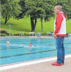  ?? SZ-FOTO: PRANDL ?? Schwimmmei­ster Uwe Hoffmann geht im Ehinger Freibad seinem Traumberuf nach. Auch bei düsterem Wetter kommen Besucher.