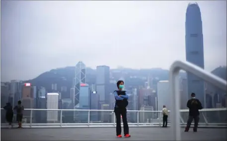  ?? EDMOND TANG / CHINA DAILY ?? A smattering of visitors in surgical masks stroll the observatio­n deck at Harbour City, Hong Kong, as the novel coronaviru­s continues to cast a cloud of unease over the city.