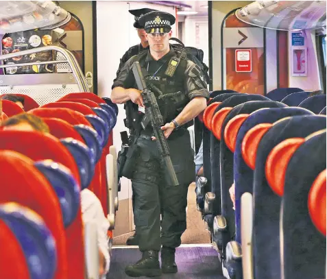  ??  ?? Armed British Transport Police officers on a Virgin train service from London to Birmingham – the first time armed officers have been deployed to patrol trains nationwide