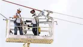  ?? CenterPoin­t Energy ?? CenterPoin­t electricia­ns install conductors near Kemah.