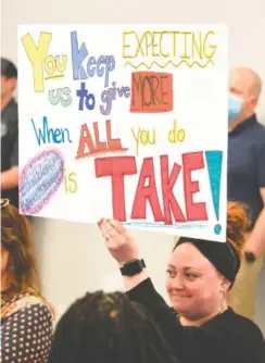  ?? ?? East Lake Elementary School teacher Jehann Kazem holds up a sign Thursday during a Hamilton County school board work session.