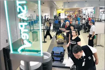  ?? Joe Raedle Getty Images ?? THE ACLU says in a lawsuit that it suspects the TSA is looking at the data in electronic devices because of media reports and complaints from domestic travelers. Above, f liers at Miami Internatio­nal Airport in 2016.