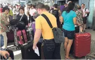  ?? AP PHOTOS ?? Passengers stand with their luggage outside Terminal 5 at London’s Heathrow airport after flights were cancelled due to the airport suffering an IT systems failure, yesterday.