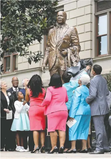  ?? ASSOCIATED PRESS PHOTOS ?? A statue paying tribute to civil rights leader Martin Luther King Jr. is unveiled Monday on the state Capitol grounds in Atlanta. The statue’s unveiling Monday came more than three years after Georgia lawmakers endorsed the project.