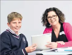  ??  ?? Finding solutions: McGuire College Year 7 student Shayden Bryant shows Christine Anderson some of his writing during the Lighthouse Project mentoring program.