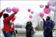  ?? CARRIE ANTLFINGER — THE ASSOCIATED PRESS ?? In this photo, Helen Jackson, left, releases balloons at Graceland Cemetery in Milwaukee with her two children Romaine Ricks, right, and Raniah Ricks, center, and Jackson’s boyfriend, Ralph Riner, in honor of what would have been her daughter, Cataleya...