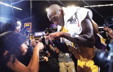  ?? Jae C. Hong / Associated Press ?? The Lakers’ Kobe Bryant fist-bumps his daughter Gianna after the last NBA game of his career in 2016, in Los Angeles. Kobe and Gianna Bryant died in a helicopter crash on Jan. 26, 2020.