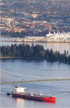  ?? JONATHAN HAYWARD / THE CANADIAN PRESS FILES ?? An oil tanker goes under Lions Gate Bridge in Vancouver. Washington state’s opposition to the Trans Mountain pipeline expansion is ironic given the state is a far bigger user of oil tankers than B.C., Tristin Hopper writes.