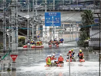  ?? Koji Harada / Associated Press ?? Rescuers on boats search in the partly submerged area after heavy rain in Kurashiki city in southweste­rn Japan. At least 112 were killed by fast-moving flooding last week. Others are still missing.